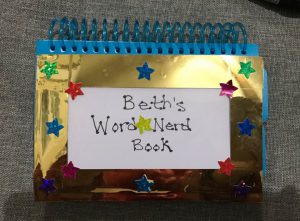 The decorated cover of the phonics flip book, trimmed with gold foil and glittery star stickers.